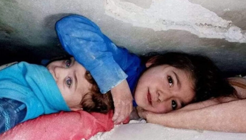 Historia e fotografisë së vajzës që mbuloi me dorë kokën e vëllait nën rrënoja (FOTO)